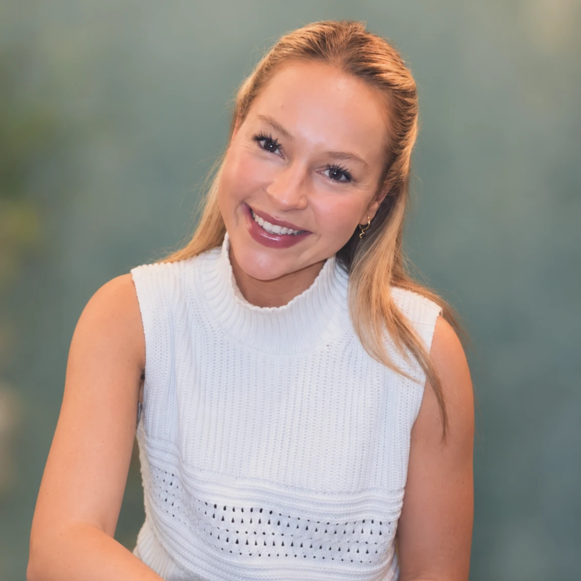 Mili Kenworthy smiling, wearing a white knitted top